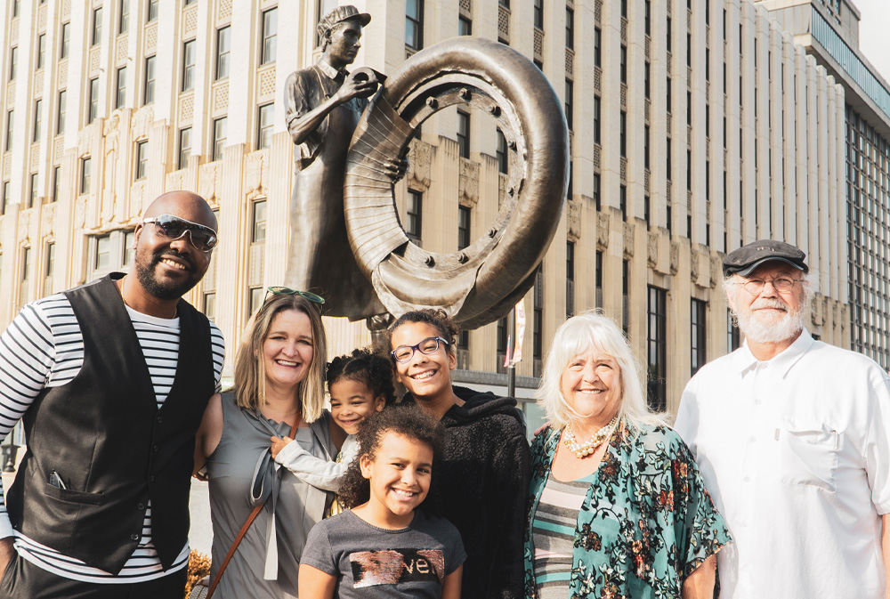 Akron family in front of tire worker statue